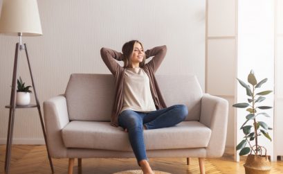 Millennial girl relaxing at home on couch, enjoying weekends, empty space