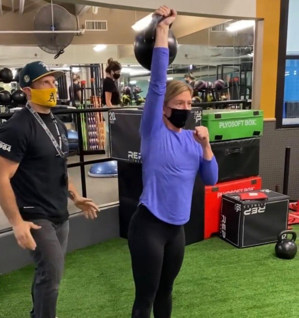 FFC Gold Coast Member Kelly lifting a 48 kg (105 lb) KB over her head.