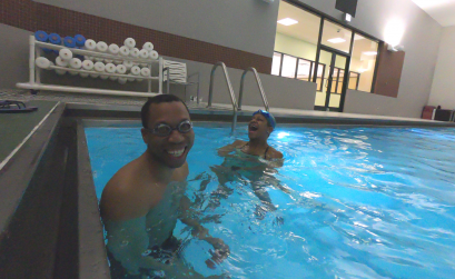 Juan smiling in pool with trainer Joy